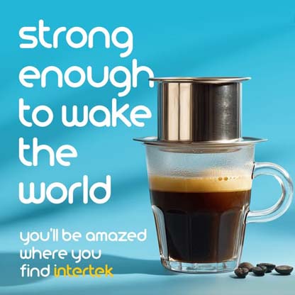 Drip coffee maker filled with coffee next to some beans